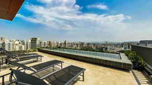 a balcony with chairs and a swimming pool on a building at 360 VN Turiassú by Housi in Sao Paulo