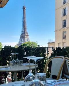 een tafel met glazen voor de Eiffeltoren bij Superbe chambre à clés Paris in Sartrouville