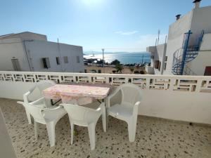 a table and chairs on a balcony with a view at Naxos Crafts' House in Naxos Chora