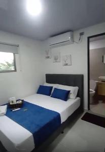 a bedroom with a large bed with blue pillows at Hotel barajas in Plazabonita +5 photos
