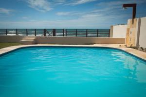a blue swimming pool with the ocean in the background at Casa encantadora com Vista Mar na Caponga in Cascavel