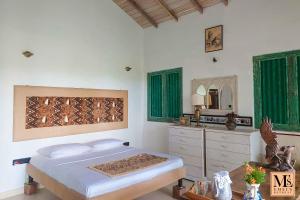 Un dormitorio con una cama, un tocador y un espejo. en Emel's Retreat, en Dikbodda