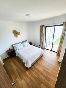 a bedroom with a white bed and a wooden floor at Downtown Punta Cana Vibrant Apartment! in Punta Cana +16 photos