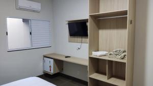Camera con letto e scrivania con TV di Hotel Habitar Serra do Salitre MG a Serra do Salitre