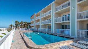 a swimming pool in front of a building at Fifty Gulfside Condominiums in Clearwater Beach