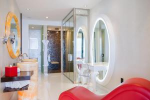 un bagno con vasca, lavandino e specchio di Hotel Mousai - Adults Only a Puerto Vallarta