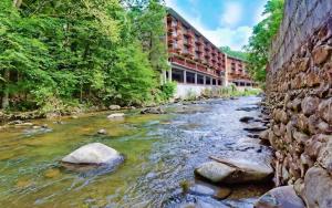 a river in front of a brick building at Simones Cottage in Gatlinburg