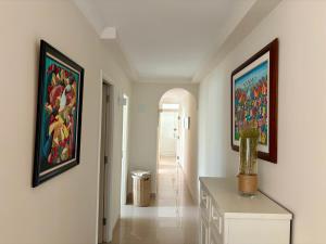 einen Flur mit zwei Gemälden an der Wand und einem Tisch in der Unterkunft Las Nasas, Vistas al Mar, 2 dormitorios in San Agustín + 25 Fotos