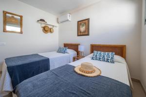 ein Zimmer mit 2 Betten mit Hut darauf in der Unterkunft Las Nasas, Vistas al Mar, 2 dormitorios in San Agustín
