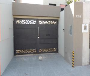 a garage with a black garage door on a building at El Refugio de Salvador in Paraná