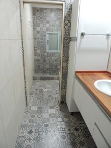 a bathroom with a shower with a sink and a mirror at El Refugio de Salvador in Paraná +8 photos