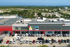 a large parking lot with cars parked in front of a building at Downtown Punta Cana Vibrant Apartment! in Punta Cana