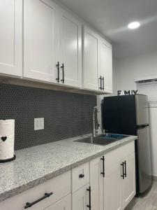 a kitchen with white cabinets and a sink and a refrigerator at Villa New Place in Las Vegas +6 photos