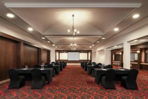 a room with a row of tables and chairs at Carlton Al Moaibed Hotel in Dammam