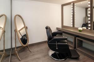 a salon with a black chair and a mirror at Carlton Al Moaibed Hotel in Dammam