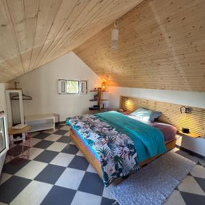 ein Schlafzimmer mit einem Bett und einer Holzdecke in der Unterkunft As Casinhas da Madeira - Cosy Stone Cottage in a subtropical garden in Arco da Calheta