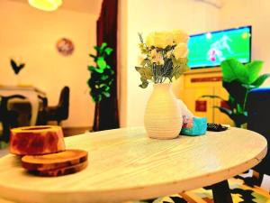 a table with a white vase with flowers on it at cozy cozy in Madinaty