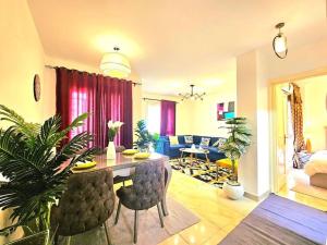 a living room with a table and chairs in a room at cozy cozy in Madinaty