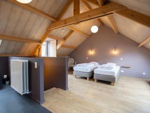 two beds in a room with wooden ceilings at Achter de Hegge in Riemst