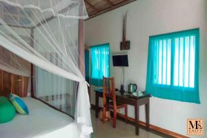 1 dormitorio con cama, escritorio, cama y ventana en Emel's Retreat, en Dikbodda