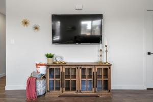 a living room with a tv on a wall at Centre Peak View I Sleep 8 I 50 TV I Full Kitchen in Pincher Creek