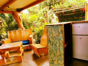a patio with a table and a chair and a refrigerator at Café Madame in Puerto López