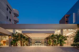 达曼卡尔顿埃尔莫埃贝德酒店的一座建筑,前方有楼梯,晚上