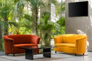 two orange chairs and a coffee table in a living room at Carlton Al Moaibed Hotel in Dammam