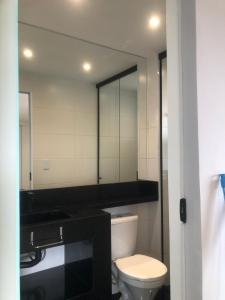 a bathroom with a toilet and a large mirror at Flat Red Sorocaba- Green in Sorocaba