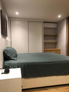 a bedroom with a bed and a book shelf at Flat Red Sorocaba- Green in Sorocaba +28 photos