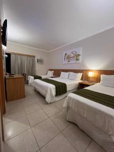 a hotel room with two beds and a television at Hotel Dom Leopoldo in São Mateus do Sul +59 photos