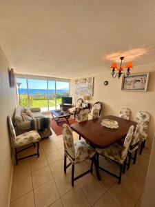 a living room with a dining room table and chairs at Arriendo de departamento Puchuncavi con vista al mar in Horcón