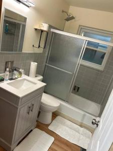 a bathroom with a shower and a toilet and a sink at Beautiful smart house for stays in Larimore +11 photos