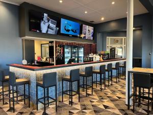 a bar in a restaurant with black bar stools at International Hotel Motel in Port Pirie