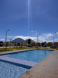 Una piscina en un estacionamiento con montañas al fondo. en Tu Hogar Encantado Casa Entera con dos Habitaciones, en San Miguel