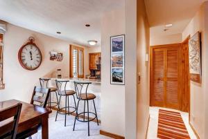 a kitchen with bar stools and a clock on the wall at Kiva 336 by East West Hospitality in Beaver Creek +18 photos