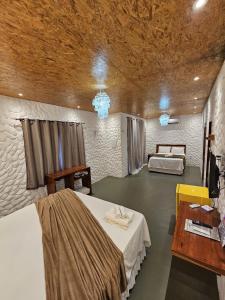 a room with two beds and a table and a desk at Kanto do Chico in Icaraí