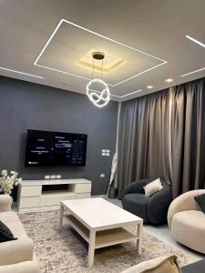 un salon avec un canapé et une télévision dans l'établissement Twin House in El patio Zahraa, à Sheikh Zayed