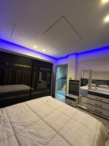 - une chambre avec un grand lit et un éclairage bleu dans l'établissement Twin House in El patio Zahraa, à Sheikh Zayed