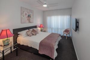 1 dormitorio con 1 cama con 2 lámparas y 1 silla en Corlette Retreat, en Corlette