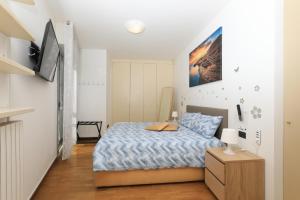 a small bedroom with a bed and a tv at Central Luxury Apt w Garage Happy Home Bergamo in Bergamo