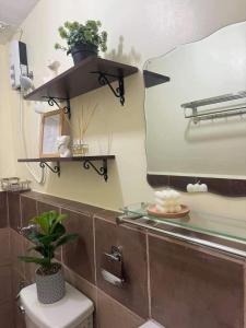 a bathroom with a mirror and a toilet and a sink at Arezzo Place Davao in Lanang +4 photos