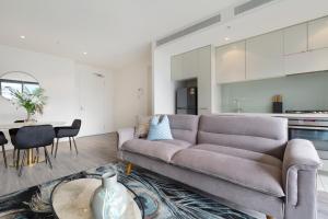 a living room with a couch and a table at Elegant City Fringe Condo w Pool & FREE Parking in Melbourne
