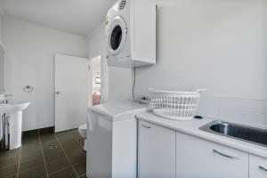 a white kitchen with a sink and a microwave at Moreton View @ Tangalooma in Tangalooma +18 photos