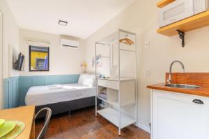 um pequeno quarto com uma cama e uma cozinha em Coração da Lagoa da Conceição-Cozinha Completa-AC em Florianópolis mais 35 fotografias