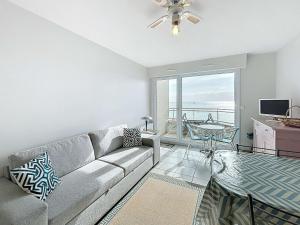 Una sala de estar con un sofá y vista al mar. en Appartement avec balcon, proche des plages et commerces - FR-1-361-89, en Granville