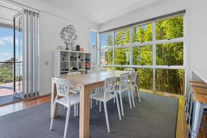 a dining room with a table and chairs and windows at DOLCE VILLA in Tangalooma