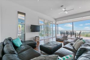 a living room with a couch and a flat screen tv at DOLCE VILLA in Tangalooma