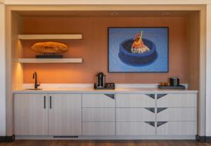 a kitchen with a sink and a painting of a chicken in a pond at Chicken Ranch Casino Resort in Jamestown