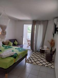 a bedroom with a bed and a living room at Appartement Nature et Mer in Sainte-Anne